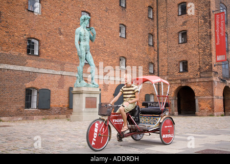 Eine Fahrradrikscha geht eine Kopie von Michelangelos David außerhalb Statens Museum für Kunst, Kopenhagen, Dänemark Stockfoto