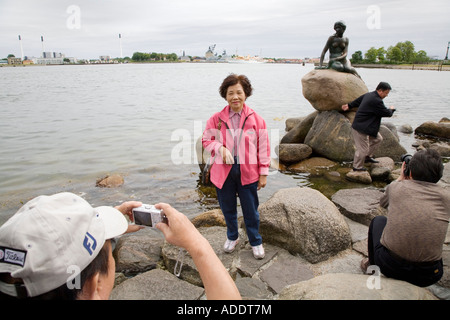 Japanische Touristen fotografieren die Statue der kleinen Meerjungfrau in Kopenhagen, Dänemark. Stockfoto