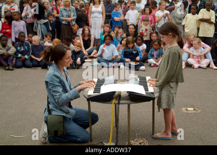 MUSIKLEHRER UND IHR STUDENT DURCHFÜHRUNG VOR DEN FAMILIEN IN SCHULE CARNAVAL JULI 2005 Stockfoto