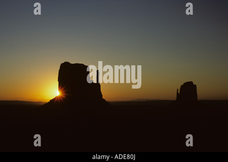 Sonnenaufgang über dem Monument Valley mit den zwei Fäustlinge Silhouette mit der Sonne um einen Arizona State USA erreichte Stockfoto