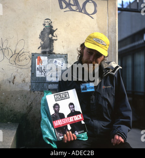 Ein Big-Issue-Verkäufer, der das Magazin-Cover mit der Massive Attack Band auf der South Bank in London, England, hält Stockfoto