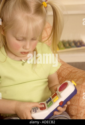 Junge Mädchen spielen mit Plastikspielzeug Telefon Stockfoto