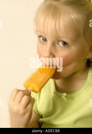 Junges Mädchen, das einen Eislolly, eisige Lollys, britische Hitzewellen saugt Stockfoto