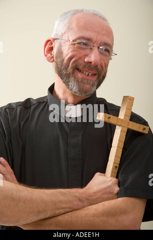 Pfarrer kommuniziert mit gedrückter Holzkreuz. Stockfoto