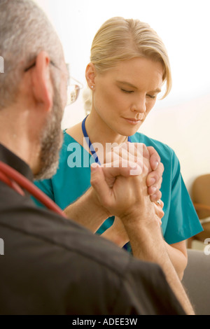 Krankenhaus Klerus betet mit Krankenschwester. Stockfoto