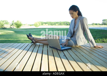 Geschäftsfrau, die sitzen auf der Terrasse, mit Laptop Stockfoto