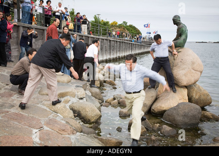 Japanische Touristen fotografieren die Statue der kleinen Meerjungfrau in Kopenhagen, Dänemark. Stockfoto