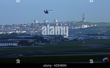 Hubschrauber startet vom Flughafen Aberdeen am Abend mit der Stadt im Hintergrund Stockfoto