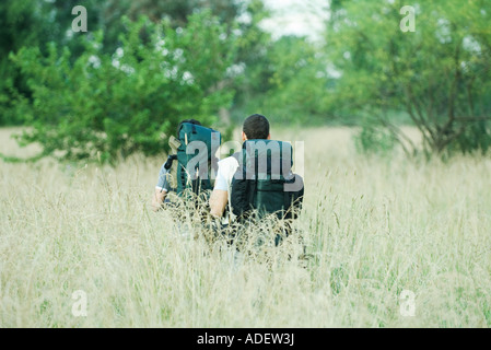 Zwei Wanderer zu Fuß durch Feld, Rückansicht Stockfoto