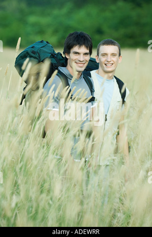 Zwei Wanderer stehen im Feld, lächelnd in die Kamera Stockfoto