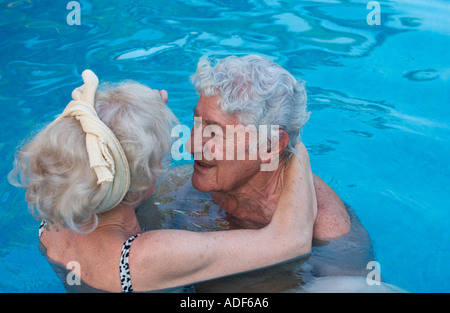 älteres Ehepaar umarmt im Schwimmbad Stockfoto