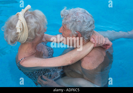 älteres Ehepaar umarmt im Schwimmbad Stockfoto