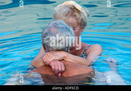 älteres Ehepaar umarmt im Schwimmbad Stockfoto