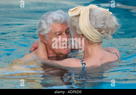 älteres Ehepaar umarmt im Schwimmbad Stockfoto