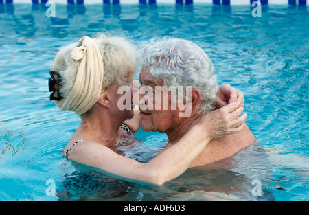 älteres Ehepaar umarmt im Schwimmbad Stockfoto