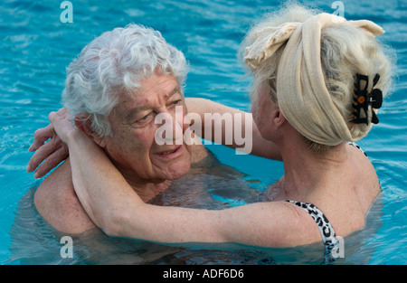 älteres Ehepaar umarmt im Schwimmbad Stockfoto