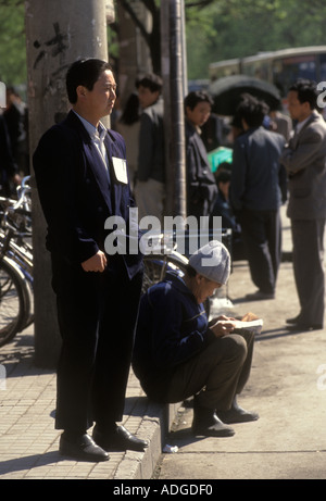 Peking China 1990er. Arbeitslose warten auf Beschäftigungsmöglichkeiten. Das handgeschriebene Schild auf seiner Jacke, das seine Fähigkeiten anpreist. 1998 HOMER SYKES Stockfoto