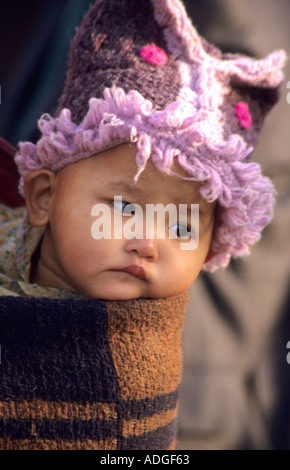 Burmesische Baby in rosa Hut durchgeführt in einer Schlinge auf ihre Mütter zurück Burma, Myanmar, Stockfoto