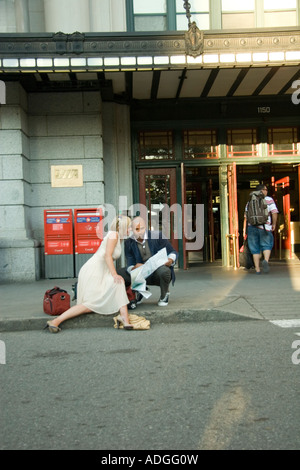 Interracial paar am vorderen Stufen eines Bahnhofs Blick auf eine Karte Stockfoto