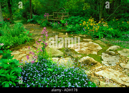 Rustikalen handgefertigten Zedernholz Bank in abgelegenen Teil des schattigen Frühlingsgarten mit Steinplatten Oberfläche Missouri Vereinigte Staaten von Amerika uns Stockfoto