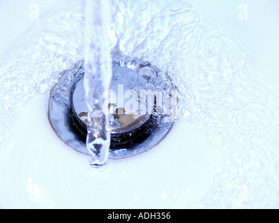 Wasser läuft nach unten ein Dübelloch schließen Stockfoto
