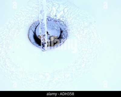Wasser läuft nach unten ein Dübelloch Stockfoto