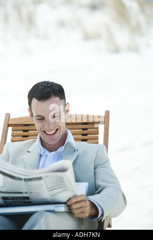 Geschäftsmann, sitzen im Liegestuhl, lesen Zeitung, Lächeln Stockfoto