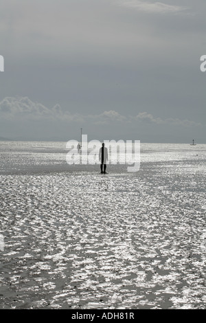 Anthony Gormley einen anderen Ort eine Reihe von Abbildung Skulpturen am Strand Windkraftanlagen im Hintergrund bei Crosby in der Nähe von Liverpool Merseyside england Stockfoto