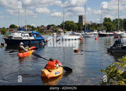 Kanus am Fluss Stour, mit Christchurch Priory im Hintergrund, Dorset, Großbritannien Stockfoto