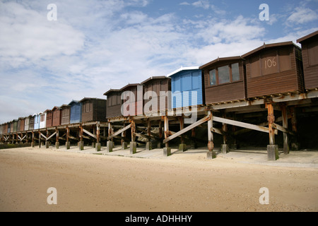 Strandhütten auf Stelzen an den niedrigen Gezeiten, Frinton auf Sea, Essex, England, UK Stockfoto