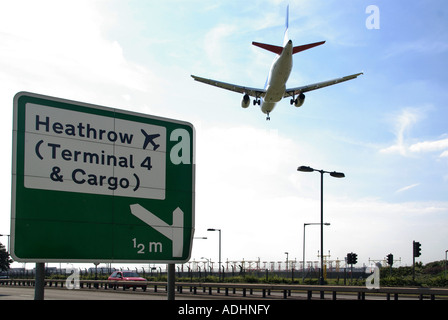 Flughafen Heathrow Straßenschild für terminal 4 Bereich Jet Frachtflugzeuge, Landeanflug niedrig über Schnellstraße Richtung Stockfoto