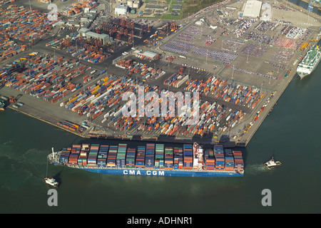 Luftaufnahme eines Containerschiffes bei Southampton Containerterminal wird eingespannt in Position durch zwei Schlepper Stockfoto