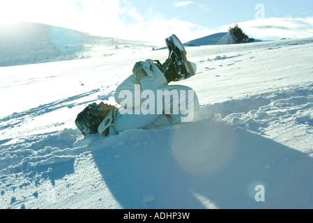 Teengirl im Schnee liegend holding Knie Stockfoto