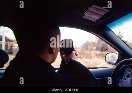 Polizist in Kreuzer mit einem handheld Laser messen die Geschwindigkeit der Autofahrer sitzen. Kansas City, MO, PD, USA. Stockfoto