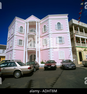 Basseterre, St. Kitts rosa Gebäude Balkone Autos Parken In der Straße Stockfoto