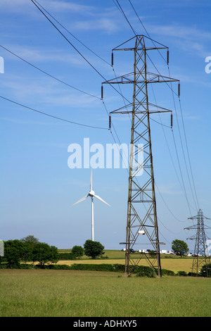 Pylone tragen macht durchqueren ein Feld mit einem Windgenerator Stockfoto