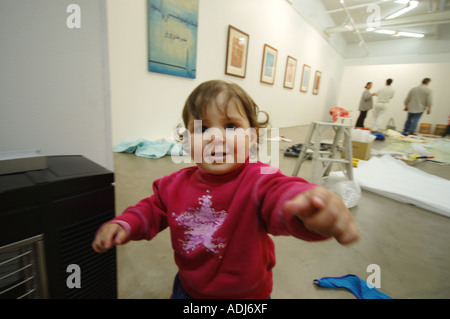 Kinder, die am hÃ ¤ ngen des Kunstausstellung warten, während Mama und Freunden Ausstellung vorbereiten Stockfoto