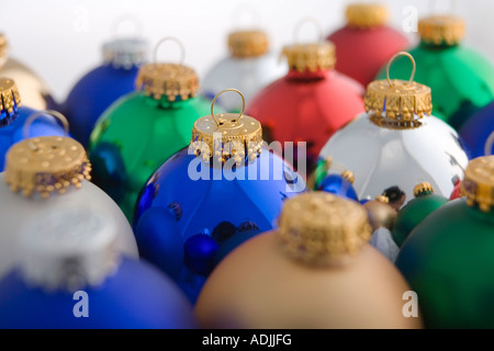 Nahaufnahme des grünen Weihnachtsbaum Birne Ornament gestapelt neben anderen bunten Ornamenten auf weißem Hintergrund Studioportrait Stockfoto