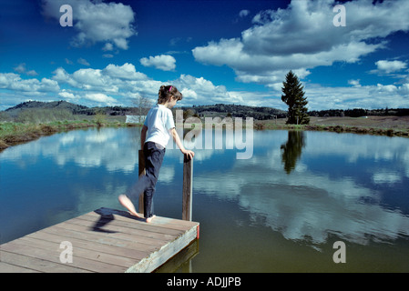 Junges Mädchen auf Dock am Teich in der Nähe von Alpine Oregon Stockfoto