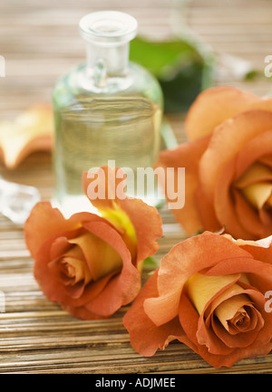 Orange Rosen mit Flasche Duftöl Stockfoto