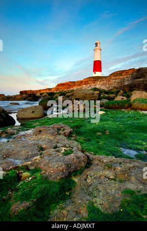 Portland Bill Leuchtturm in der Dämmerung aus dem vorland unter den tückischen Landspitze Felsen, die das Meer bei Ebbe Stockfoto