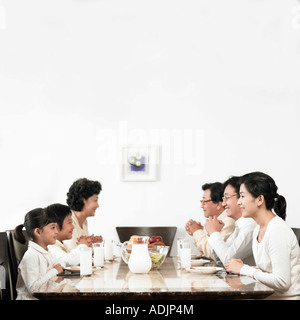 Eine koreanische Großfamilie ist beten vor dem Essen in der Küche Stockfoto