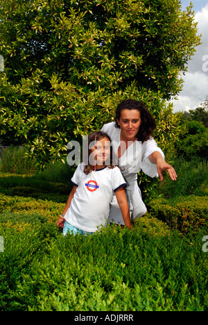 36 Jahre alte Frau mit ihrer 8-jährigen Tochter im Garten Fulham Palace London genießen Stockfoto