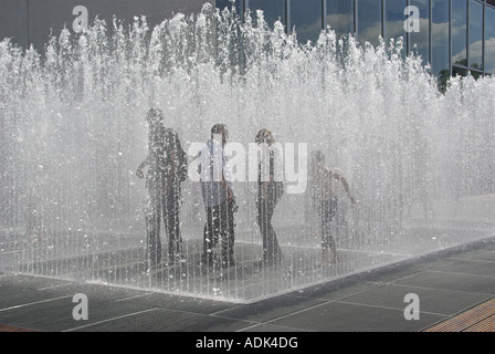 Southbank komplexen "erscheinenden Räumen" boxed Wasserspiel Brunnen stehen bei dem Versuch, trocken zu bleiben oder um sich abzukühlen Stockfoto