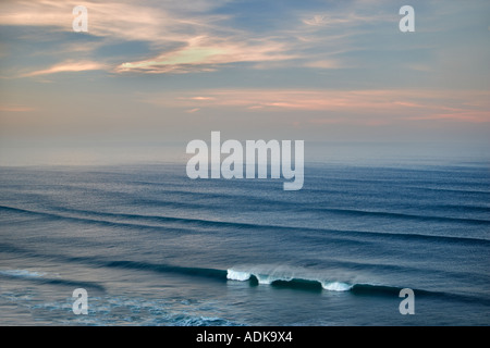 Sonnenaufgang und Wolken mit Wellen Cannon Beach, Oregon Stockfoto