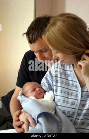 Stolze Eltern, halten ihre schlafenden neugeborenen Babys in eine Decke gehüllt. Stockfoto