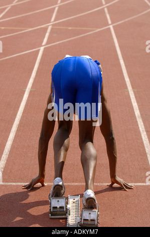 Männliche Läufer kauerte in Startlöchern Stockfoto