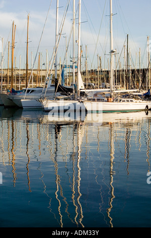 Yachten und ihre Masten spiegelt sich im Wasser durch das Abendlicht Port Vell Barcelona Katalonien Spanien Stockfoto