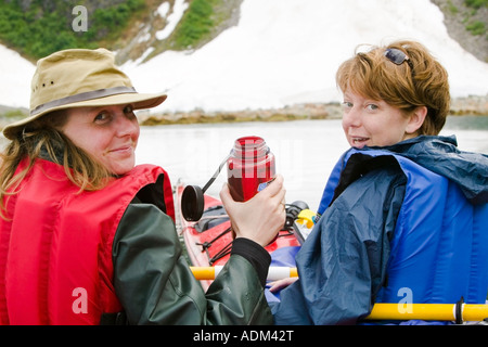Zwei Erwachsene kaukasischen Frauen Kajakfahrer nehmen paddeln Pause in Aialik Bay Kenai Fjords Nationalpark Yunan Alaska hautnah Stockfoto