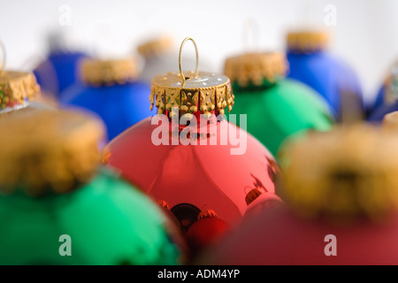 Nahaufnahme des grünen Weihnachtsbaum Birne Ornament gestapelt neben anderen bunten Ornamenten auf weißem Hintergrund Studioportrait Stockfoto